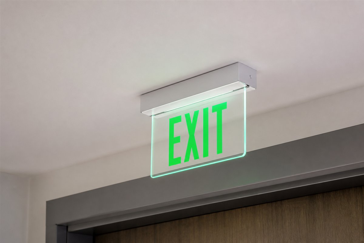 Edge-lit exit sign mounted cleanly through a finished ceiling